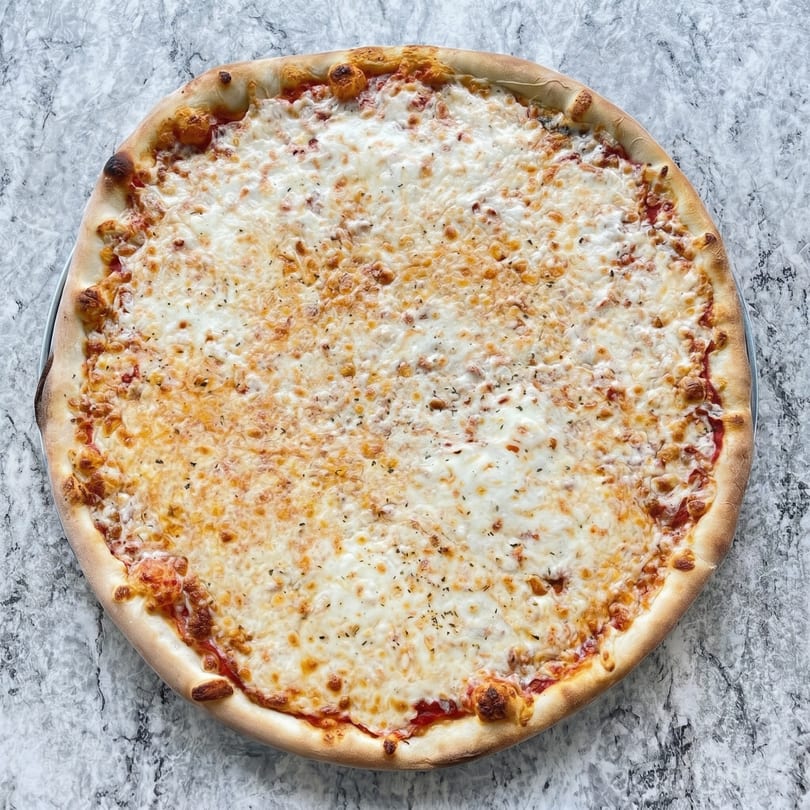 Classic cheese pizza with a golden crust, melted mozzarella, and a hint of herbs on a marble surface.